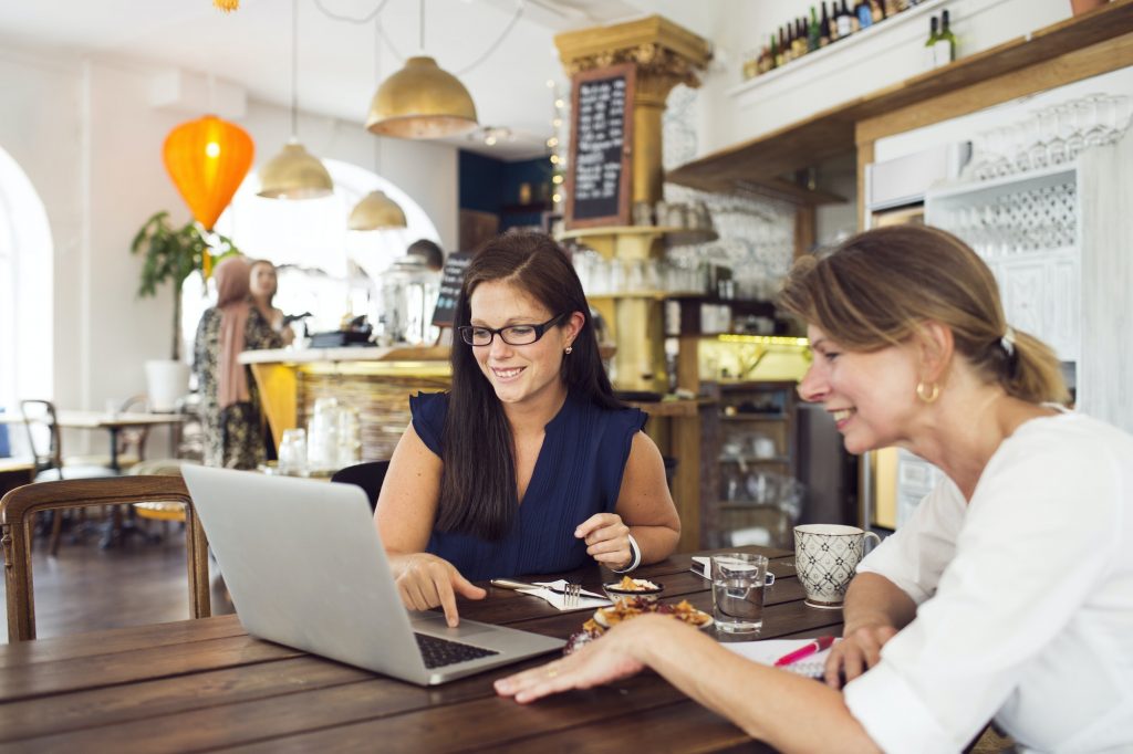 Businesswomen using laptop during lunch in restaurant