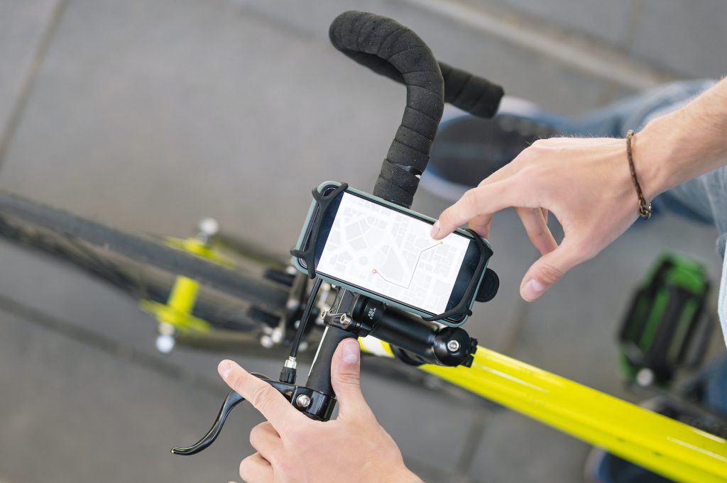 Man consulting the map with an app to know the places and make deliveries with the bicycle.
