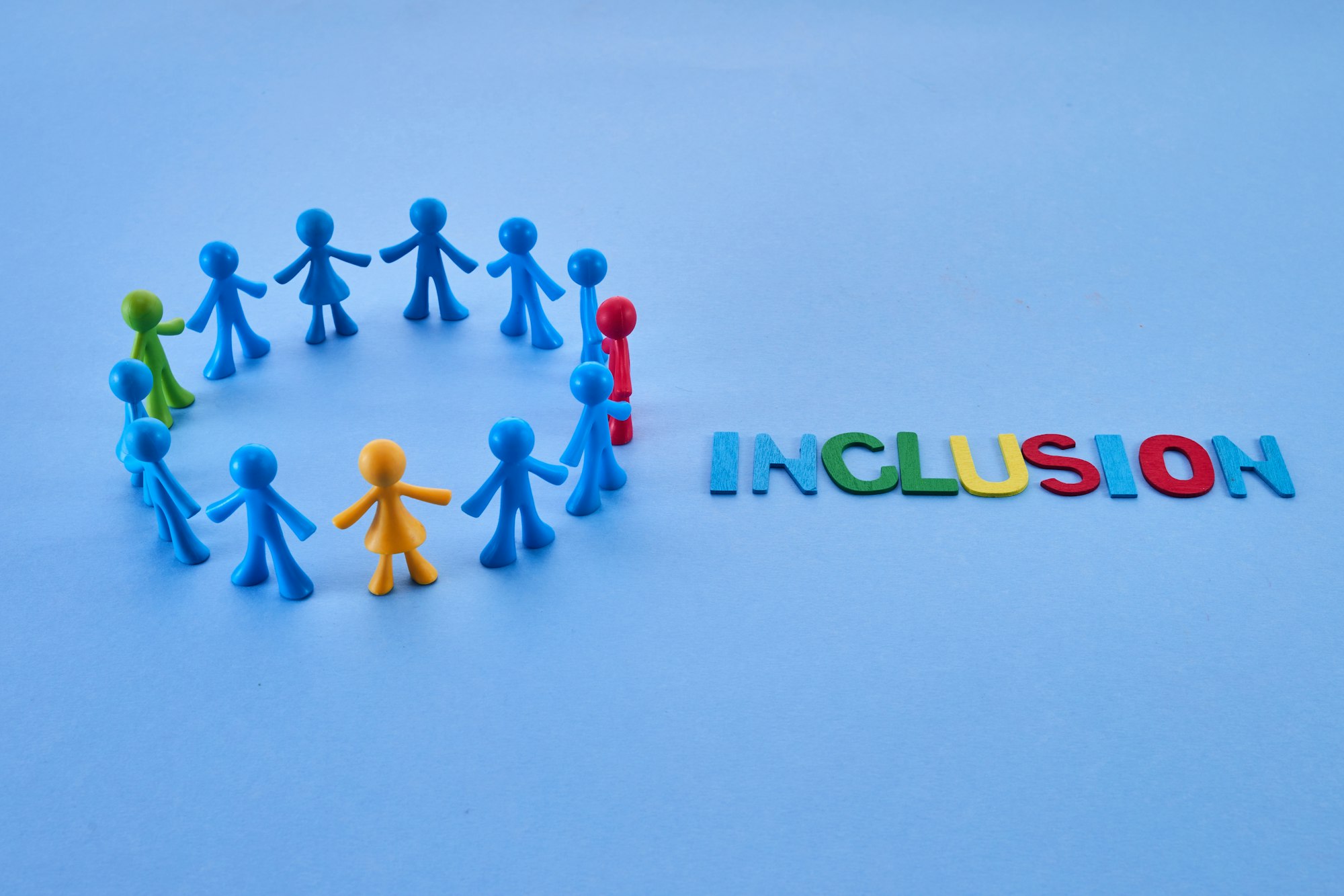 Diversity and inclusion concept. Colorful figurines on blue background